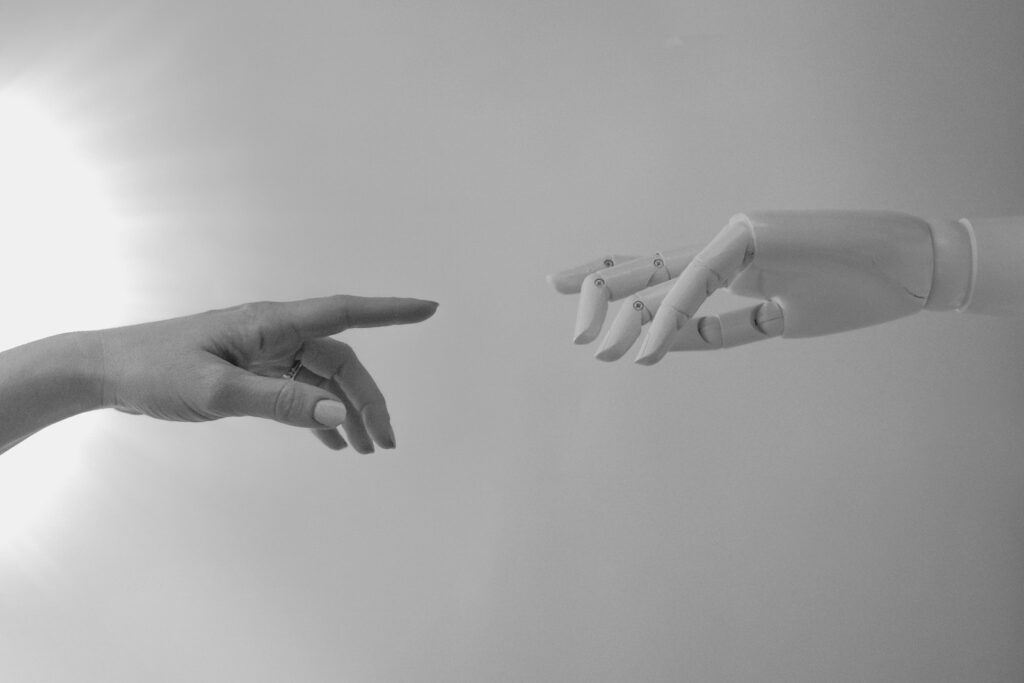 Black and White Photo of Human Hand and Robot Hand